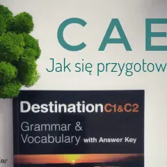 Zielona kępa mchu obok książki "Destination C1&C2 Grammar & Vocabulary" i napisu "CAE Jak się przygotować?".