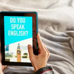 Osoba korzysta z tabletu z napisem "DO YOU SPEAK ENGLISH?", szukając darmowych narzędzi AI do nauki angielskiego.