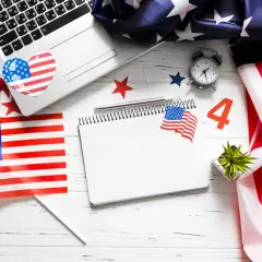 Laptop, notes, i amerykańska flaga. Czas na podsumowanie, jak zakończyć bloga po angielsku, z nutką patriotyzmu.