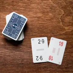 Karty do nauki tabliczki mnożenia: 2x9=18 i 6x3=18. Stos kart z niebieskim wzorem.