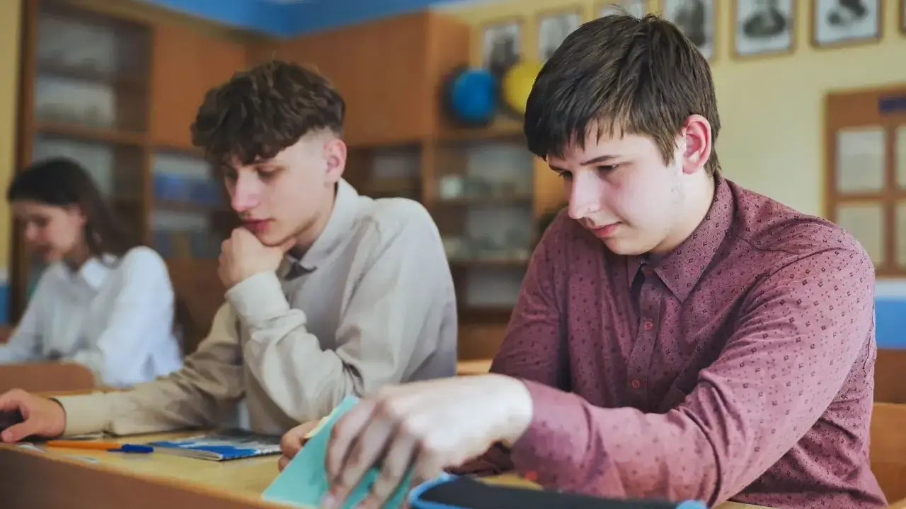 Uczniowie w klasie, zastanawiający się nad usprawiedliwieniem nieobecności w szkole powody.